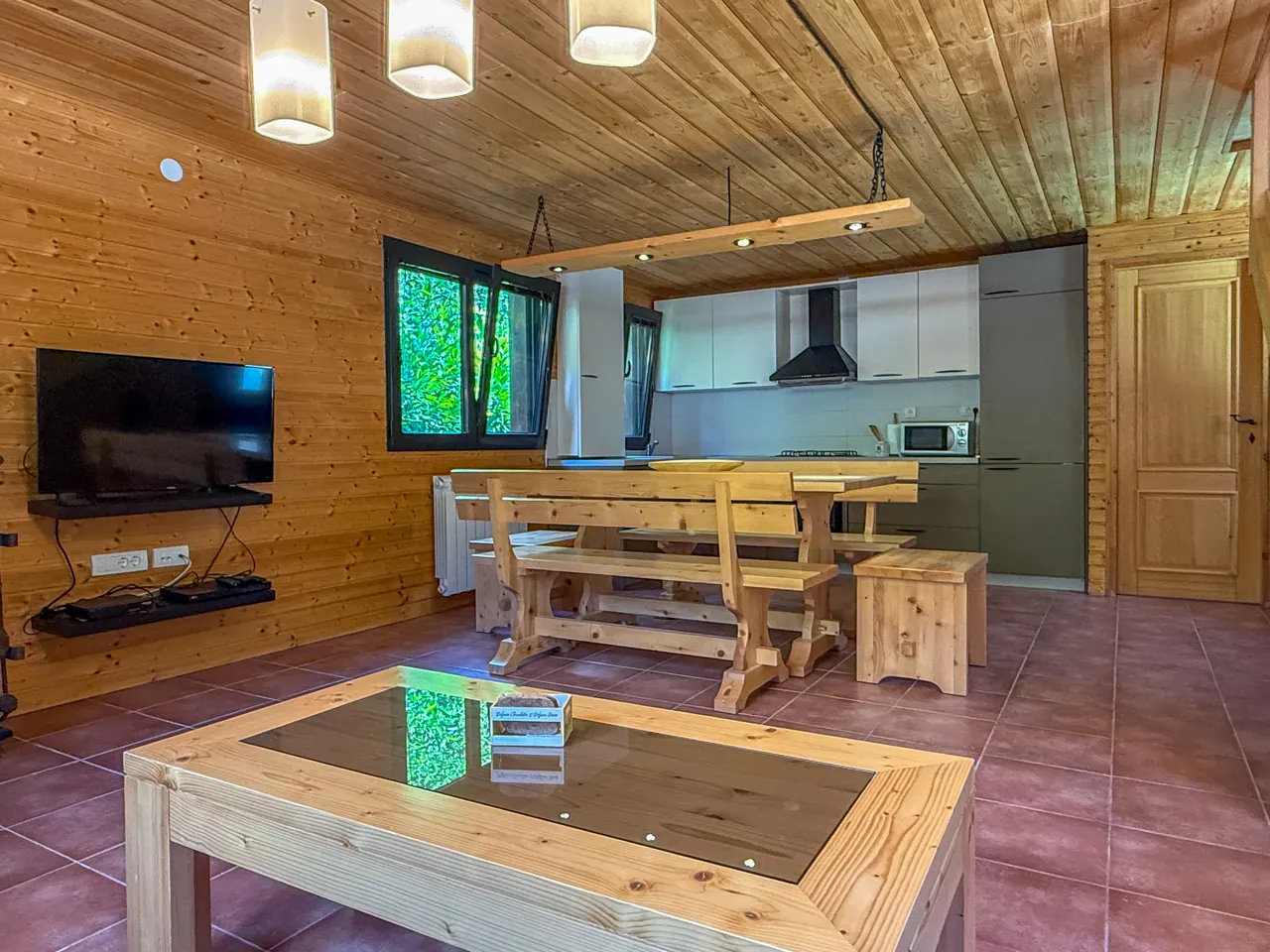 Open-plan living, dining and kitchen under a wooden ceiling