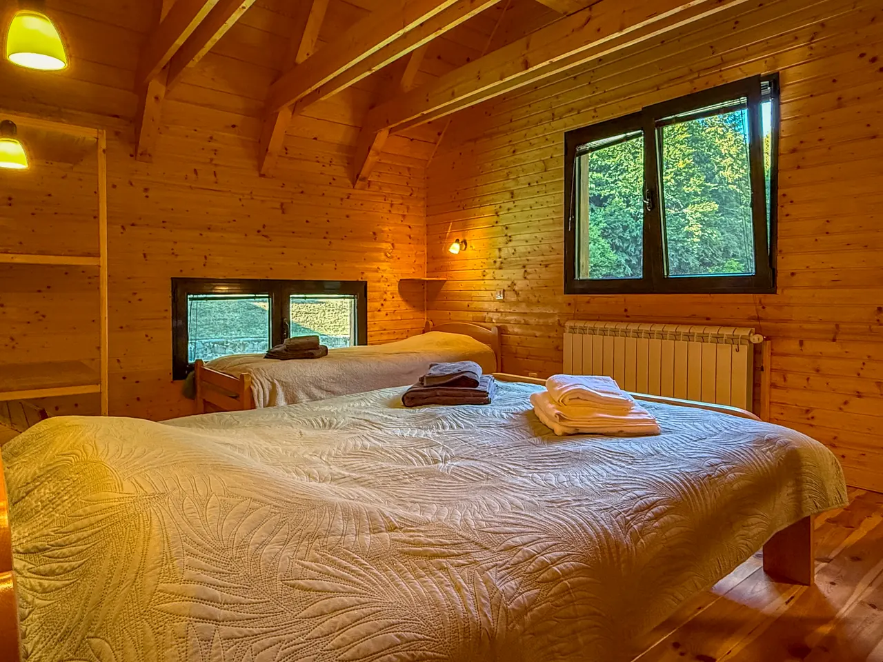 A bedroom with a double bed and a single bed under the window