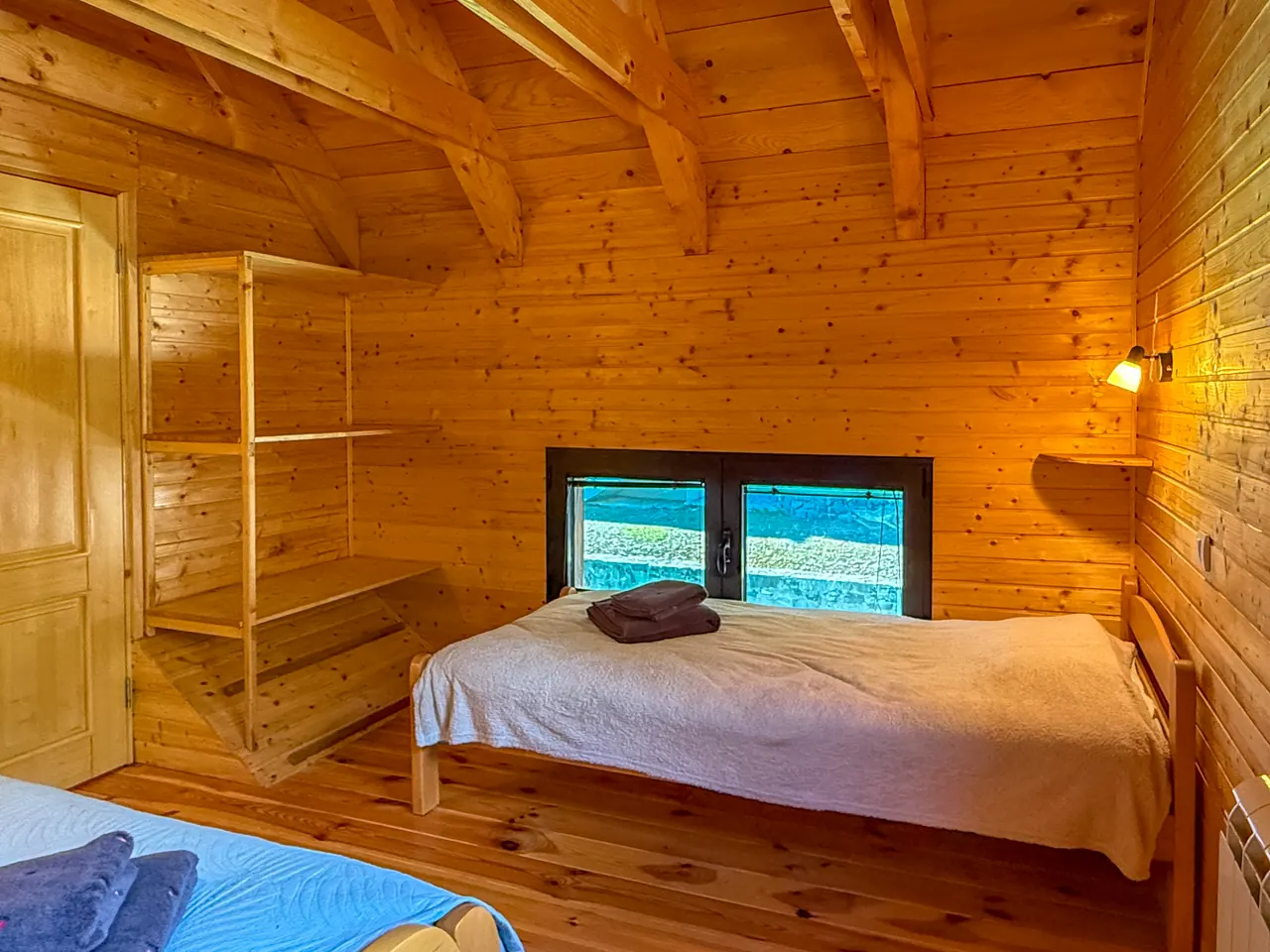 A single bed under a low window in the bedroom