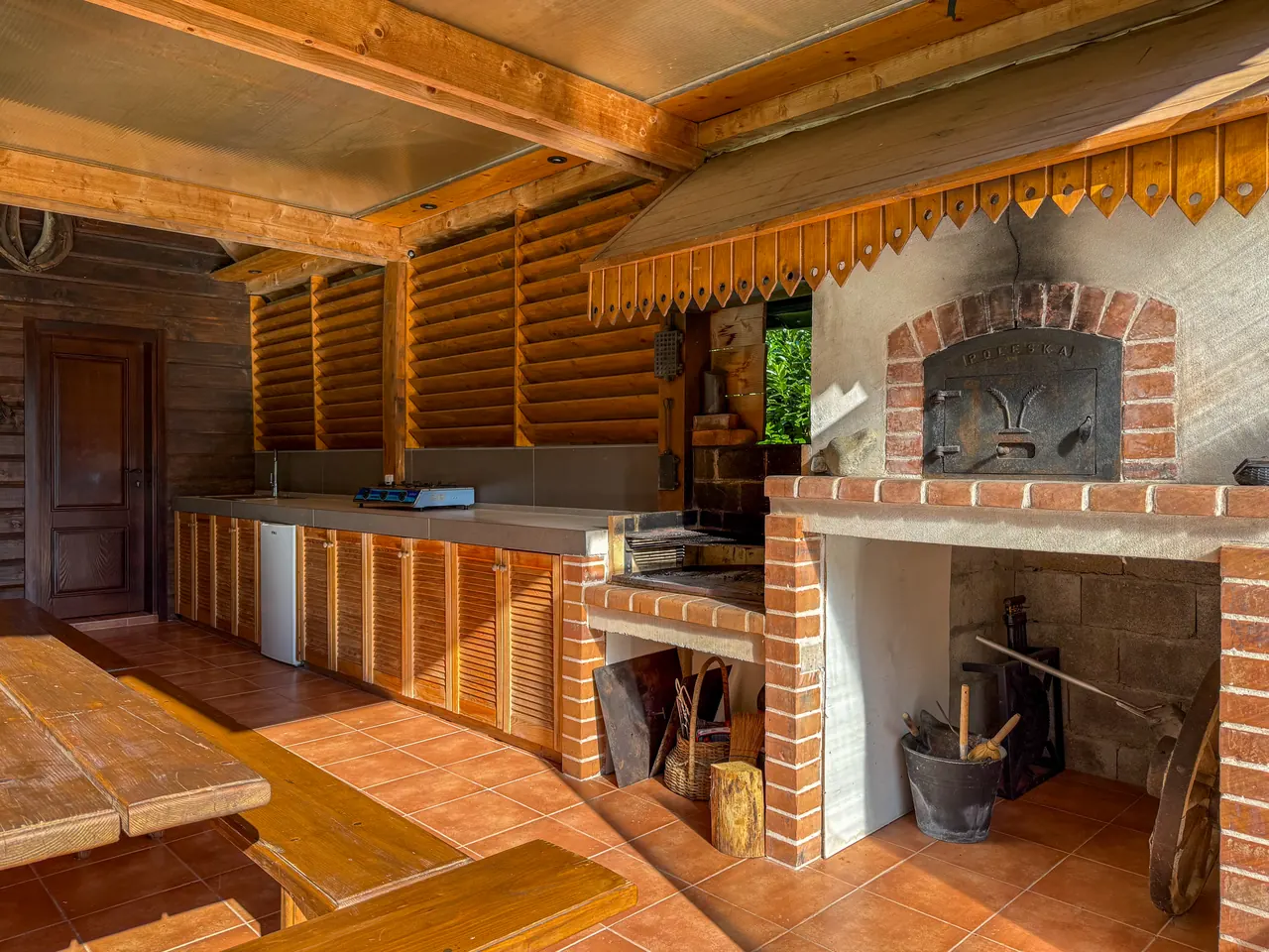 The outdoor kitchen with sink, fridge, cooker and pizza oven