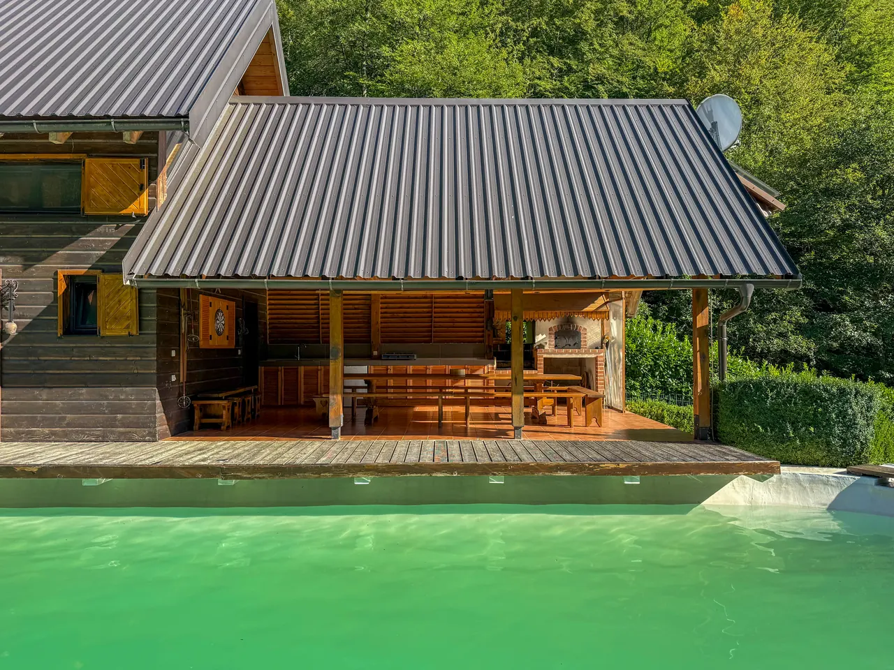 The covered outdoor kitchen behind the pool deck