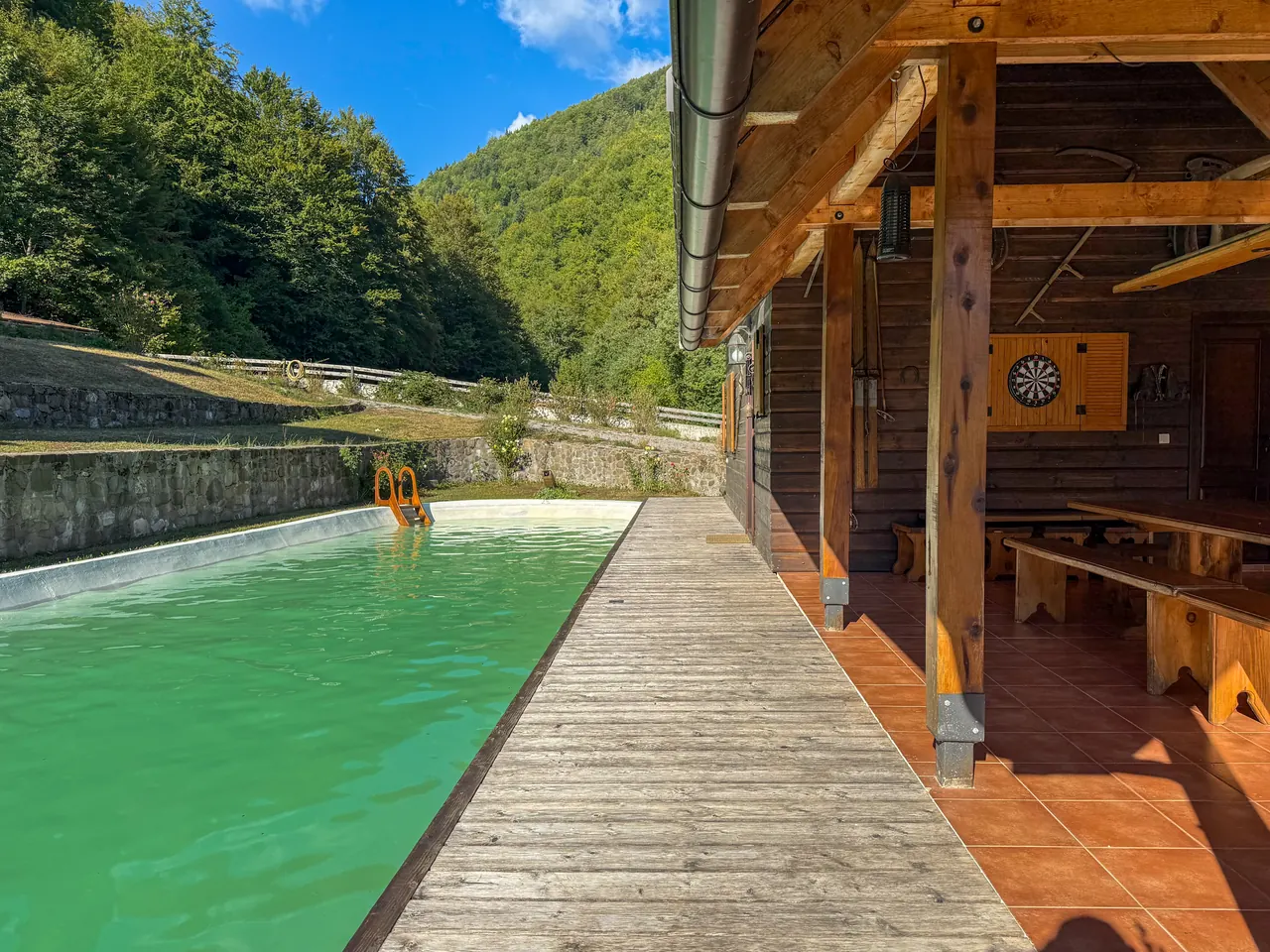 A wooden walkway along the pool, looking out over the valley