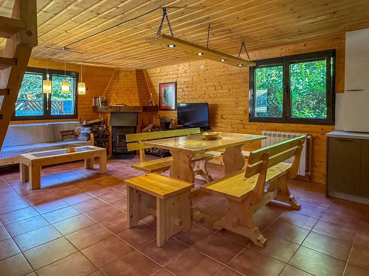 The open living area with a wooden table and the wood-burning stove